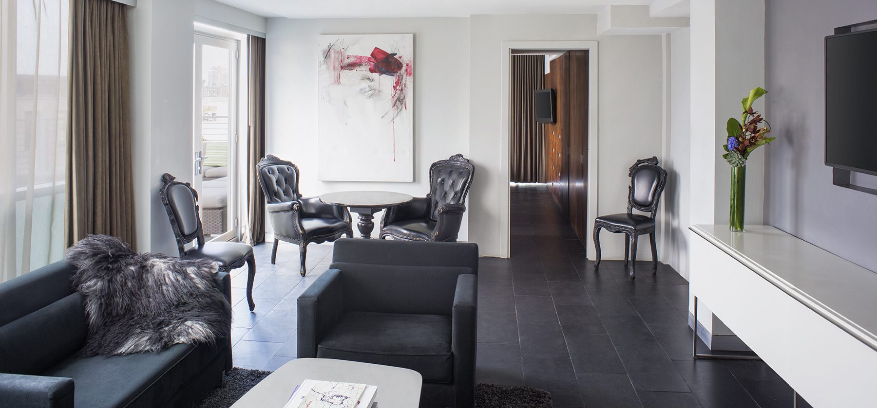 A wide view of a luxurious living room with modern furniture and decor.